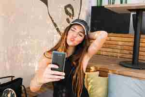 Photo gratuite belle femme moue tout en prenant selfie sur téléphone portable