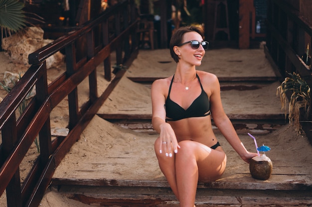 Belle femme avec noix de coco assis dans les escaliers au bar