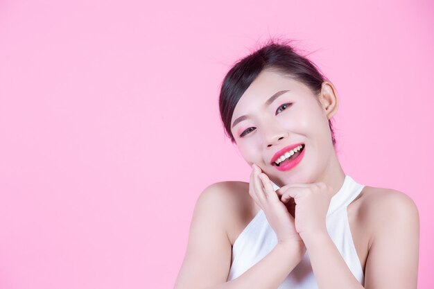 Belle femme avec une peau saine et beauté sur un fond rose.