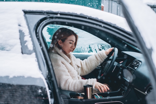 Belle femme pilote nsitting au volant de sa voiture