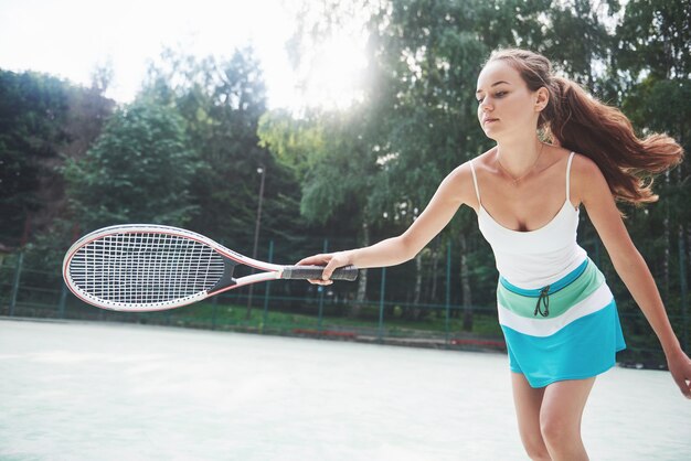 Une belle femme portant une balle de tennis sportswear.