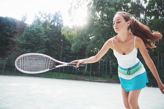 Une belle femme portant une balle de tennis sportswear.