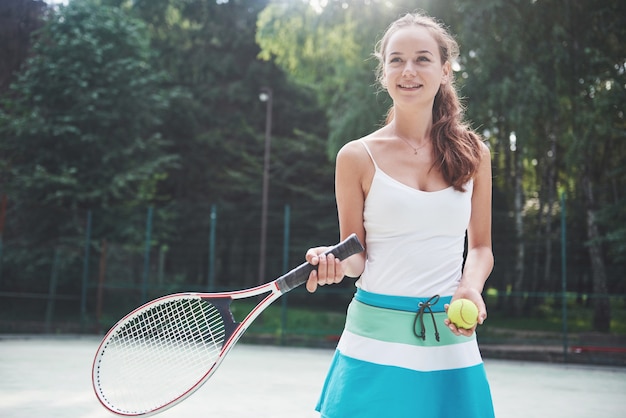 Une belle femme portant une balle de tennis sportswear.