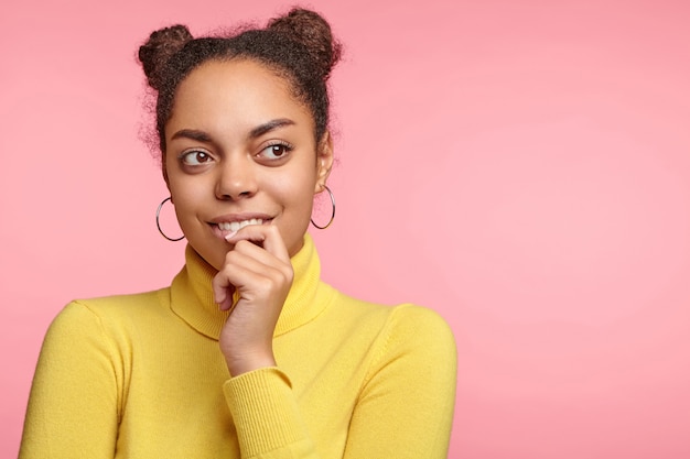 Belle femme portant des boucles d'oreilles et pull jaune