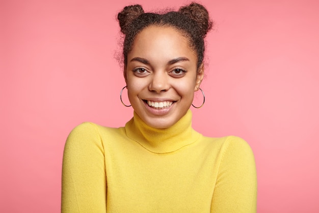 Belle femme portant des boucles d'oreilles et pull jaune