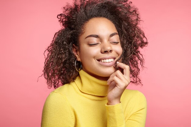 Belle femme portant des boucles d'oreilles et pull jaune