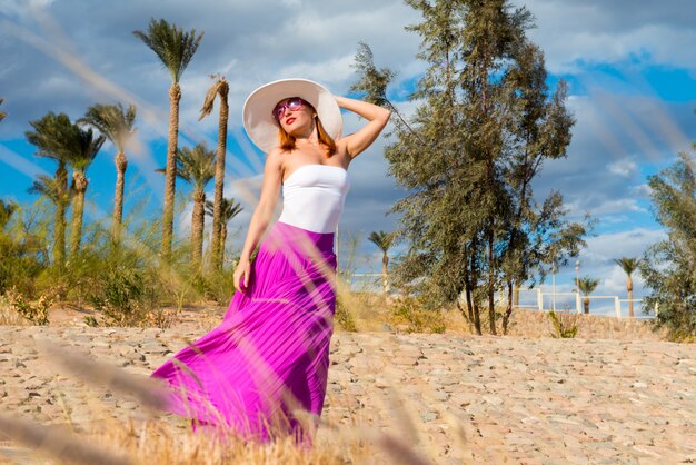 Belle femme portant un chapeau et une jupe rose