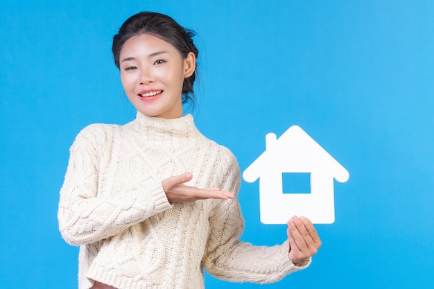 Une belle femme portant une nouvelle chemise blanche à manches longues avec un symbole de la maison. Commerce de maison.