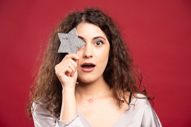 Belle femme posant avec une étoile scintillante.