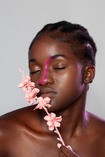 Photo gratuite belle femme posant avec fleur vue de face