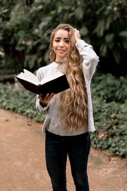 Photo gratuite belle femme posant avec un livre à la main