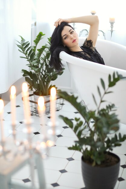 Belle femme posant à la maison dans la salle de bain