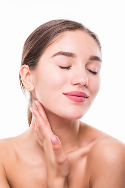 Belle femme prend soin du visage de peau posant au studio isolé sur mur blanc