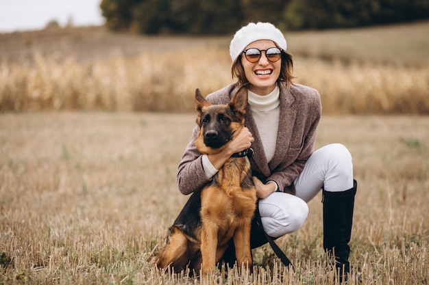 Belle femme promenant son chien dans un champ