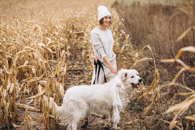 Belle femme promenant son chien dans un champ