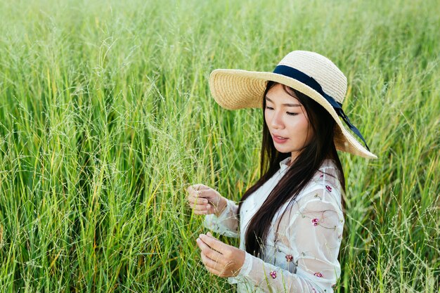 Une belle femme qui est assise dans la prairie avec joie.