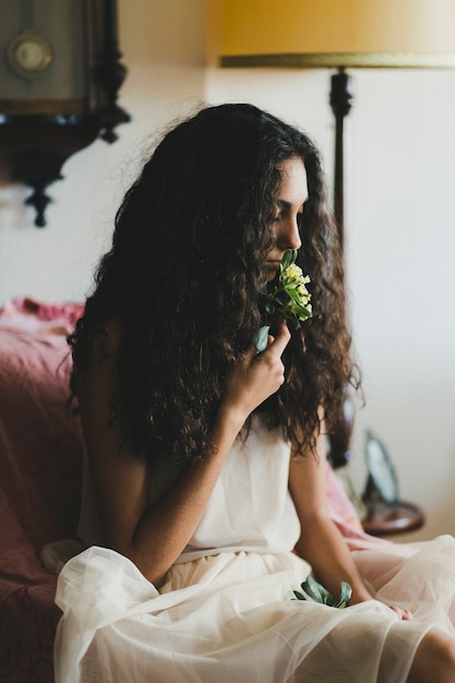 Photo gratuite belle femme qui sent la fleur