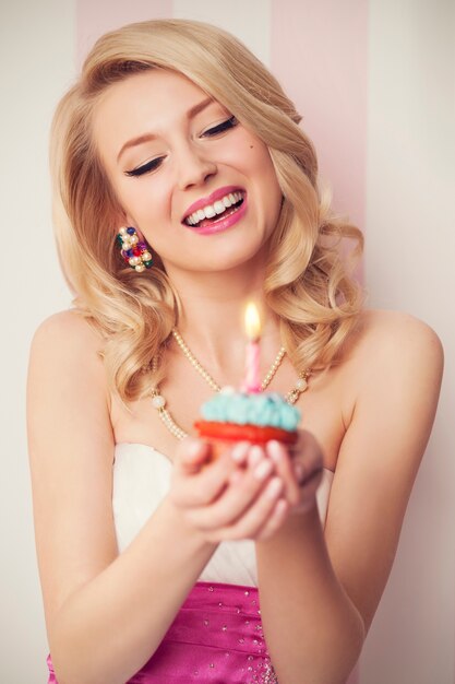 Belle femme rétro célébrer avec un muffin bleu
