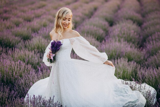 Belle femme en robe de mariée dans le champ de lavande
