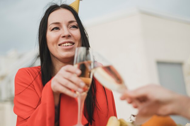 Belle femme en robe rouge réconfortant un verre de champagne