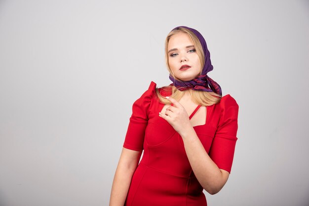 Belle femme en robe rouge regardant la caméra.