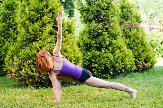 Belle femme rouge faisant des exercices de fitness ou de yoga