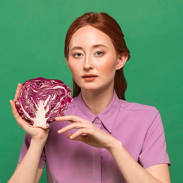 Belle femme rousse posant avec légume