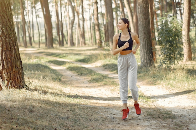 Belle femme s'exécute dans un parc d'été