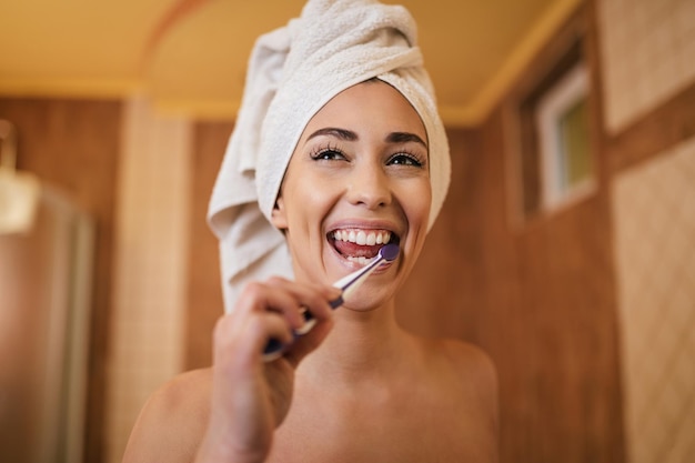 Photo gratuite belle femme se nettoyant les dents avec une brosse à dents dans la salle de bain