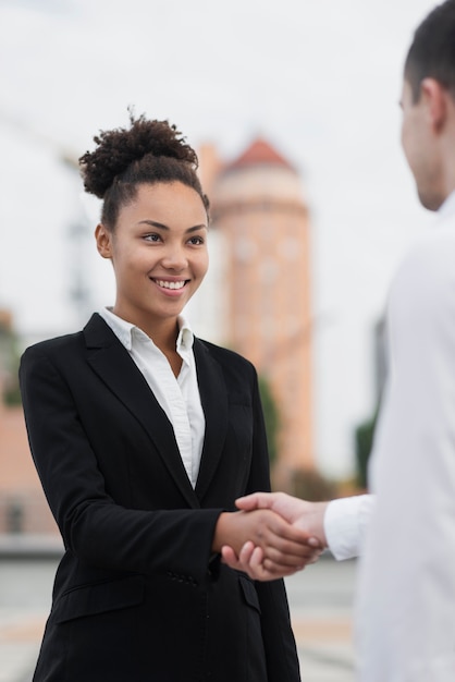 Belle femme se serrant la main avec un collègue