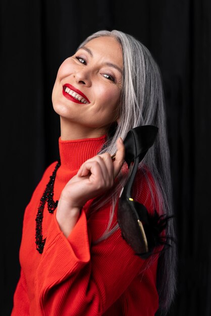 Belle femme senior avec des lèvres rouges et des talons hauts