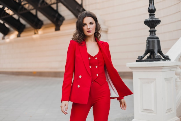 Photo gratuite belle femme sexy de style d'affaires riche en costume rouge marchant dans la rue de la ville, tendance de la mode printemps été