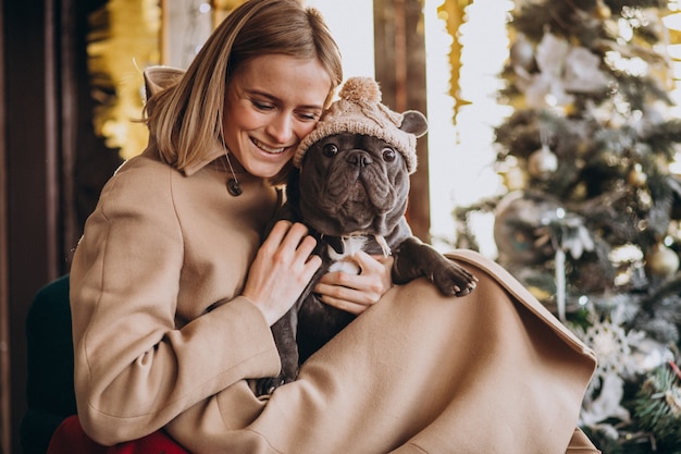 Belle femme avec son mignon bouledogue français en tenue chaude