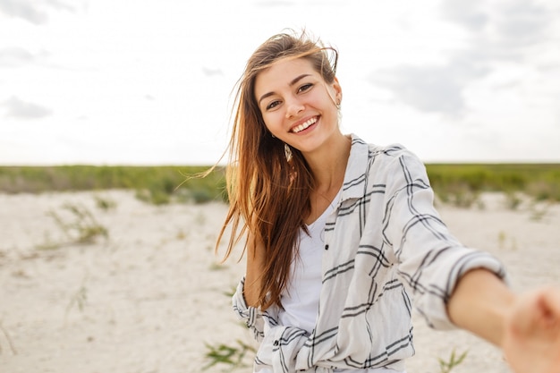 Photo gratuite belle femme souriante faisant autoportrait et profitant de vacances près de l'océan.