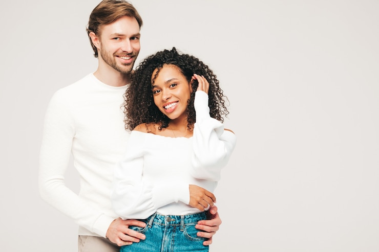 Photo gratuit belle femme souriante et son beau petit ami. joyeuse famille multiraciale joyeuse ayant des moments tendres sur gris