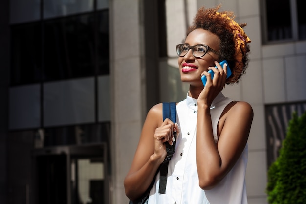 Belle femme, sourire, conversation téléphone, marche bas, ville