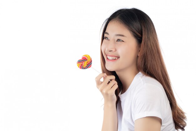 Belle femme avec un sourire heureux, tenant un bonbon à la main, isolé sur fond blanc.