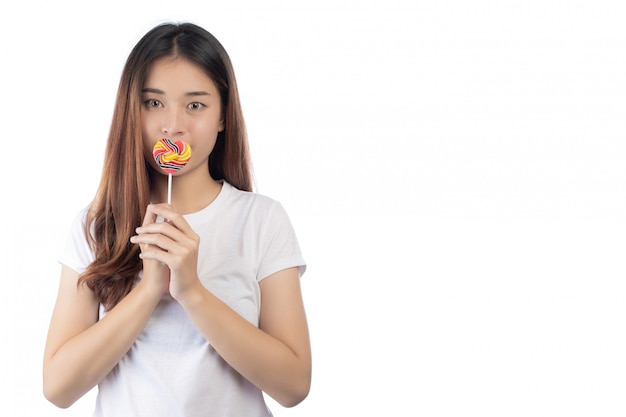 Belle femme avec un sourire heureux, tenant un bonbon à la main, isolé sur fond blanc.