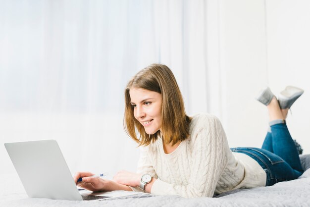 Belle femme avec un stylo en utilisant un ordinateur portable