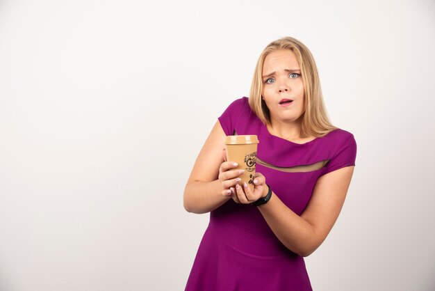 Belle femme avec une tasse de café posant.