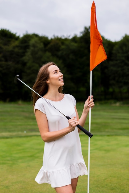 Photo gratuite belle femme tenant un bâton de golf