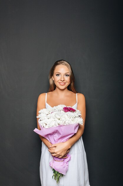 Belle femme tenant un bouquet de fleurs