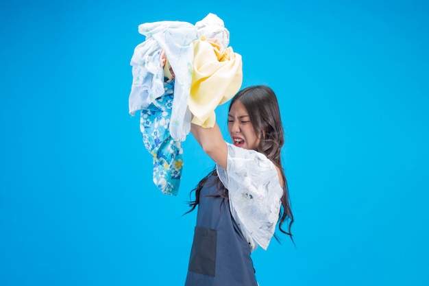 Une belle femme tenant un chiffon prêt à laver sur bleu