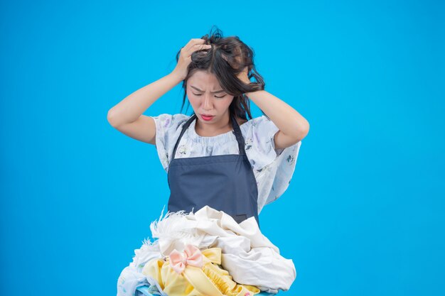 Une belle femme tenant un chiffon prêt à laver sur bleu