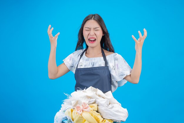 Une belle femme tenant un chiffon prêt à laver sur bleu