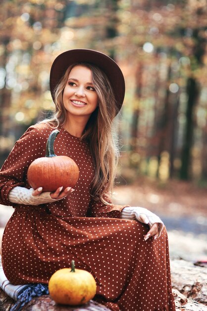 Belle femme tenant des citrouilles dans les bois d'automne