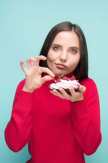 Belle femme tenant un petit gâteau