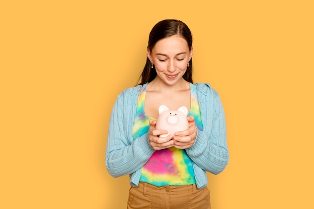 Photo gratuite belle femme tenant une tirelire pour une campagne d'épargne financière