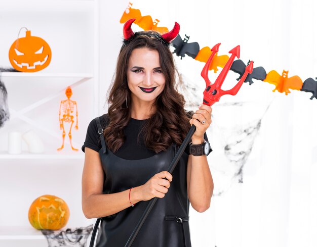 Belle femme tenant un trident d'halloween