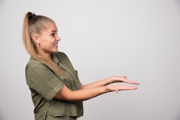 Belle femme en tenue verte montrant ses mains à quelqu'un.